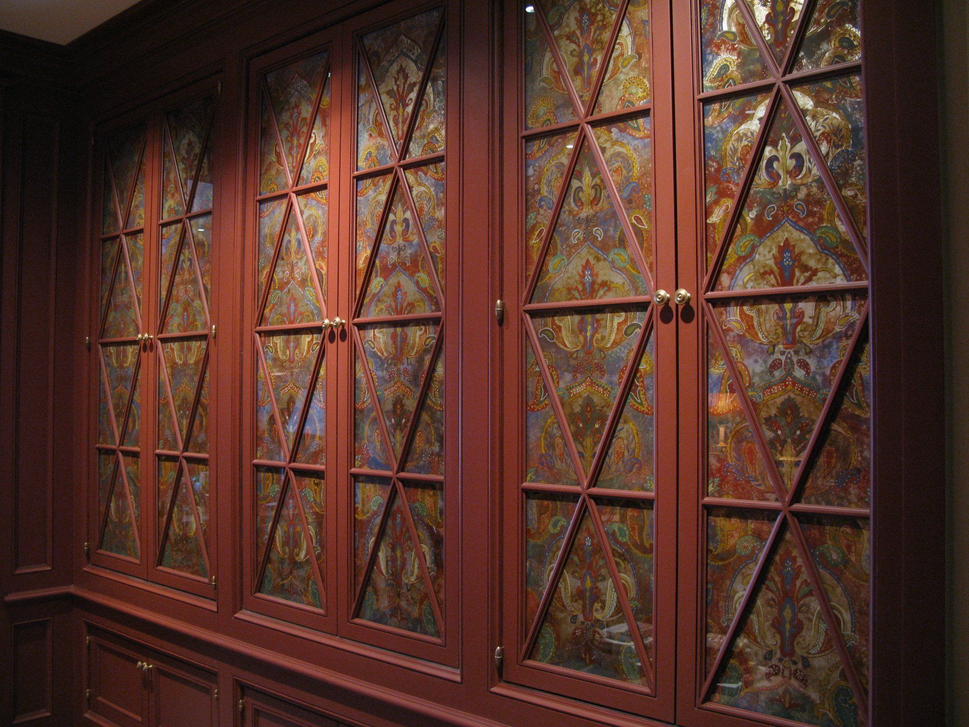A row of cabinets with stained glass doors in a room.