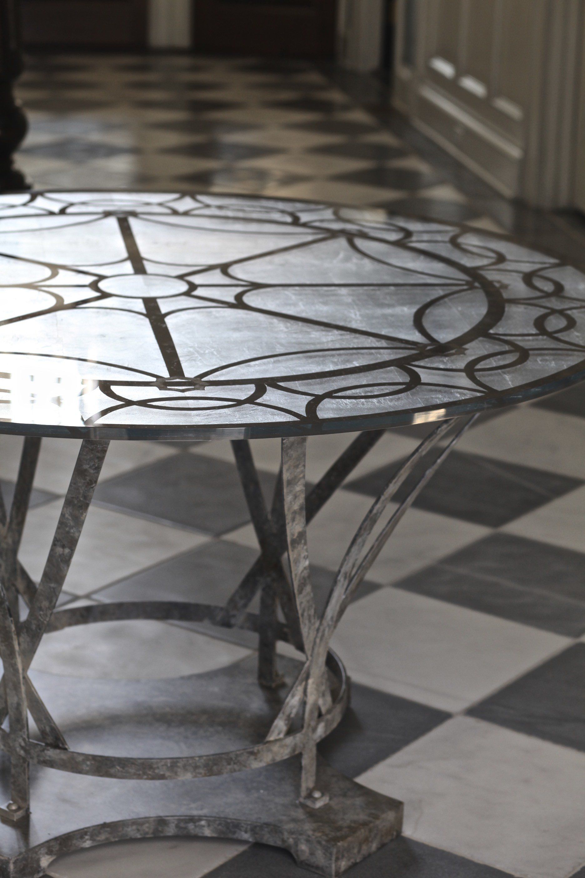 A round table is sitting on a checkered floor