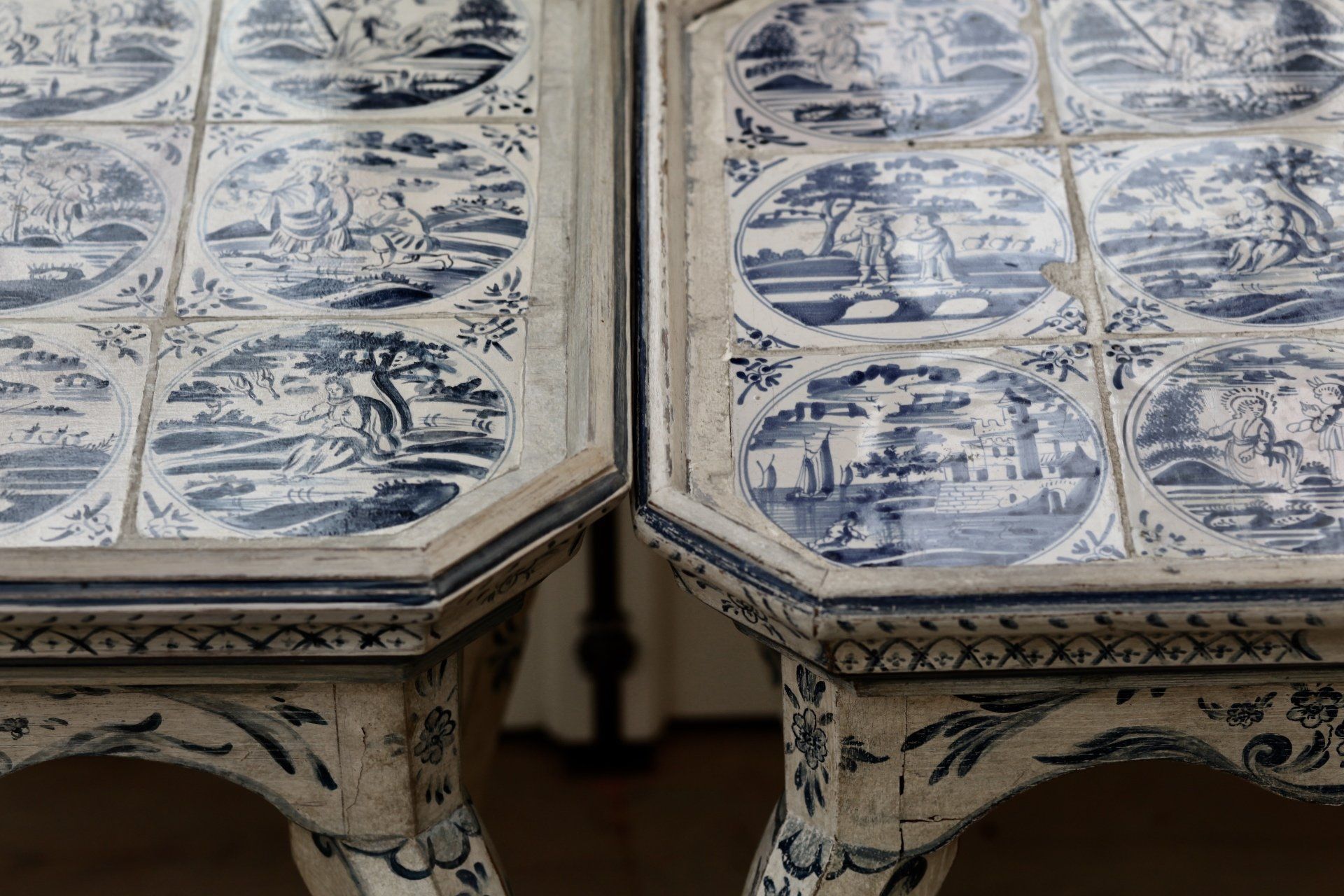 Two tables with blue and white tiles on them are sitting next to each other.