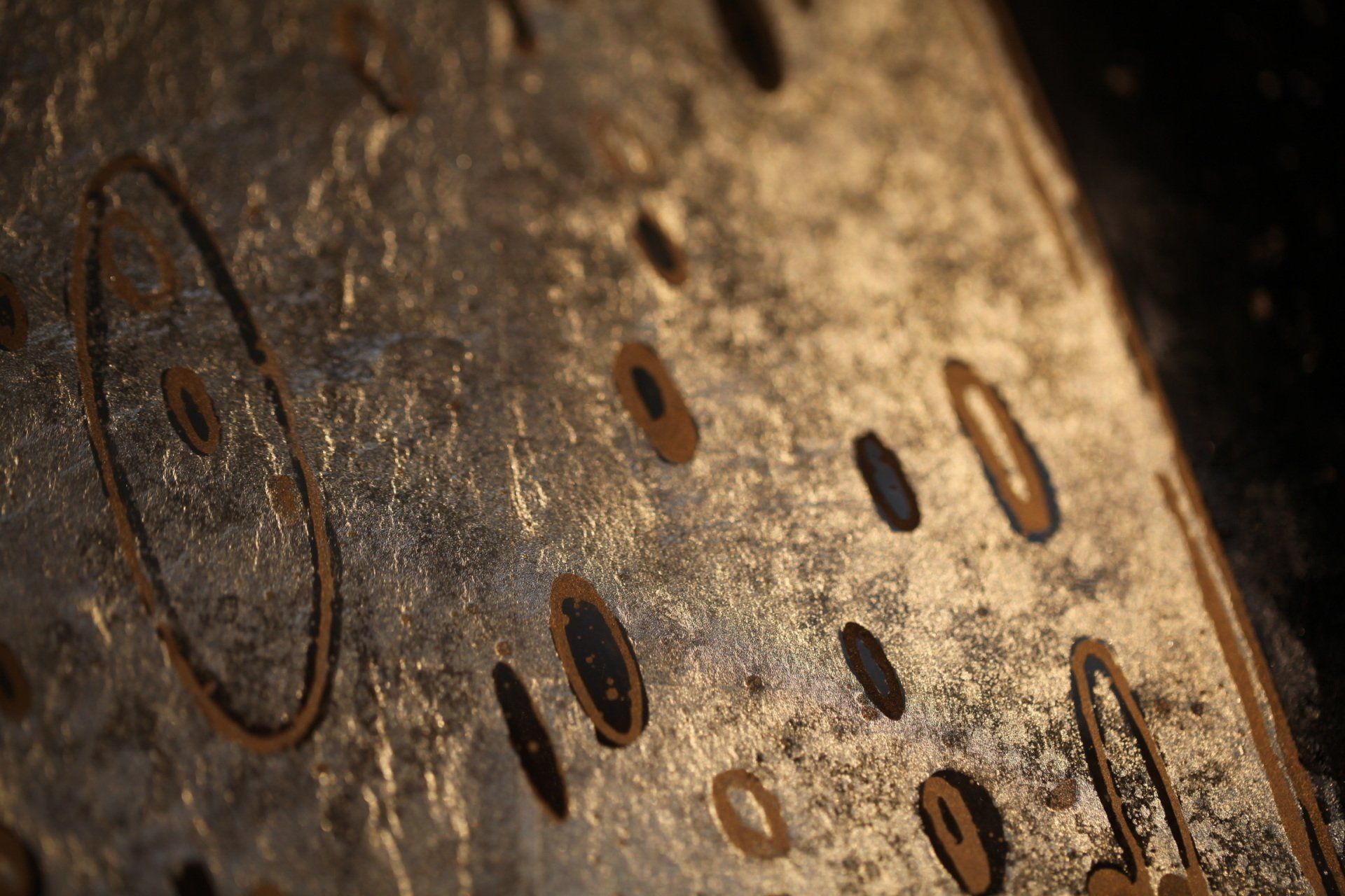A close up of a rusty metal surface with holes in it.