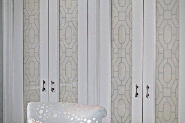 A chair is sitting in front of a wall with a pattern on it.