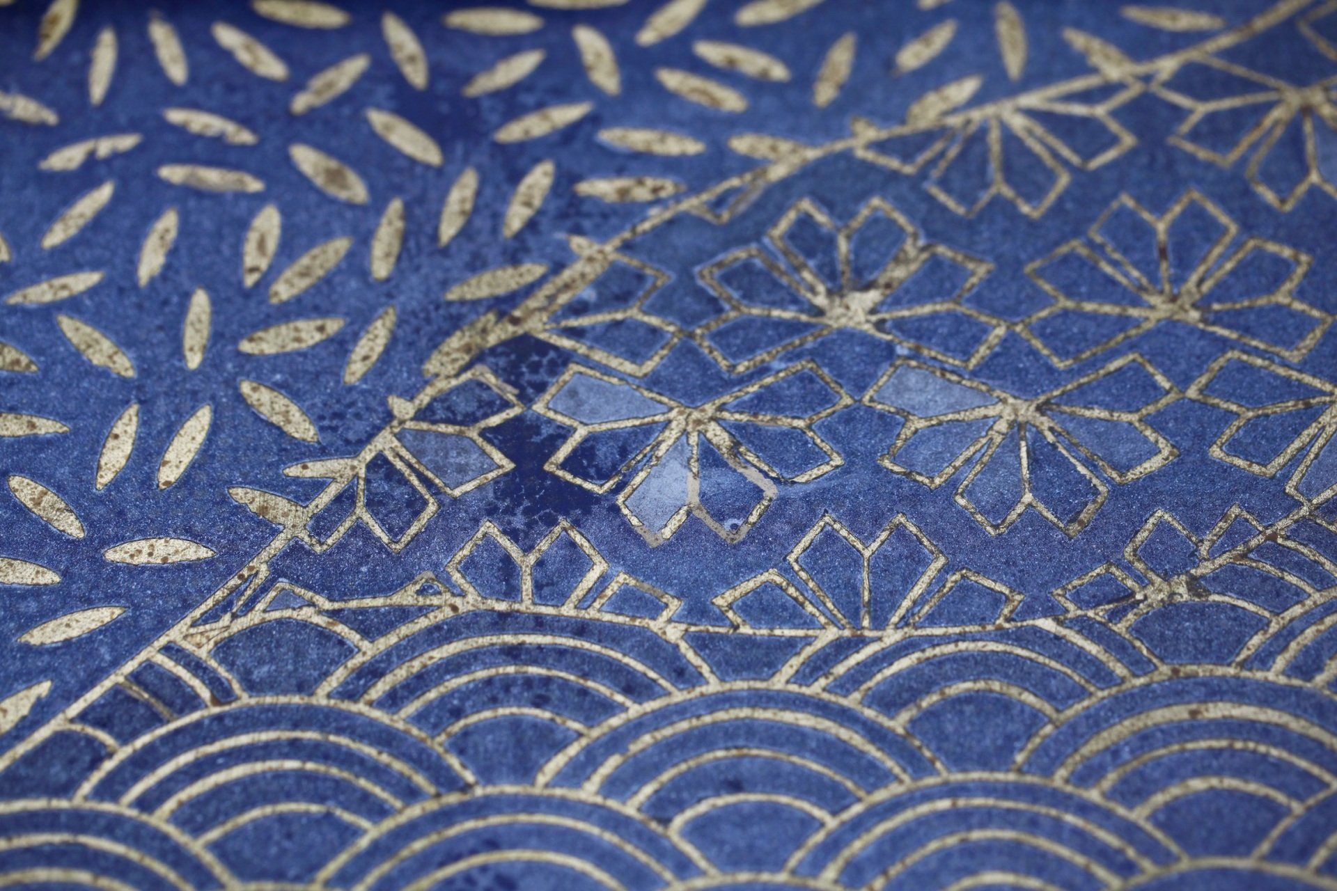 A close up of a blue and gold pattern on a fabric