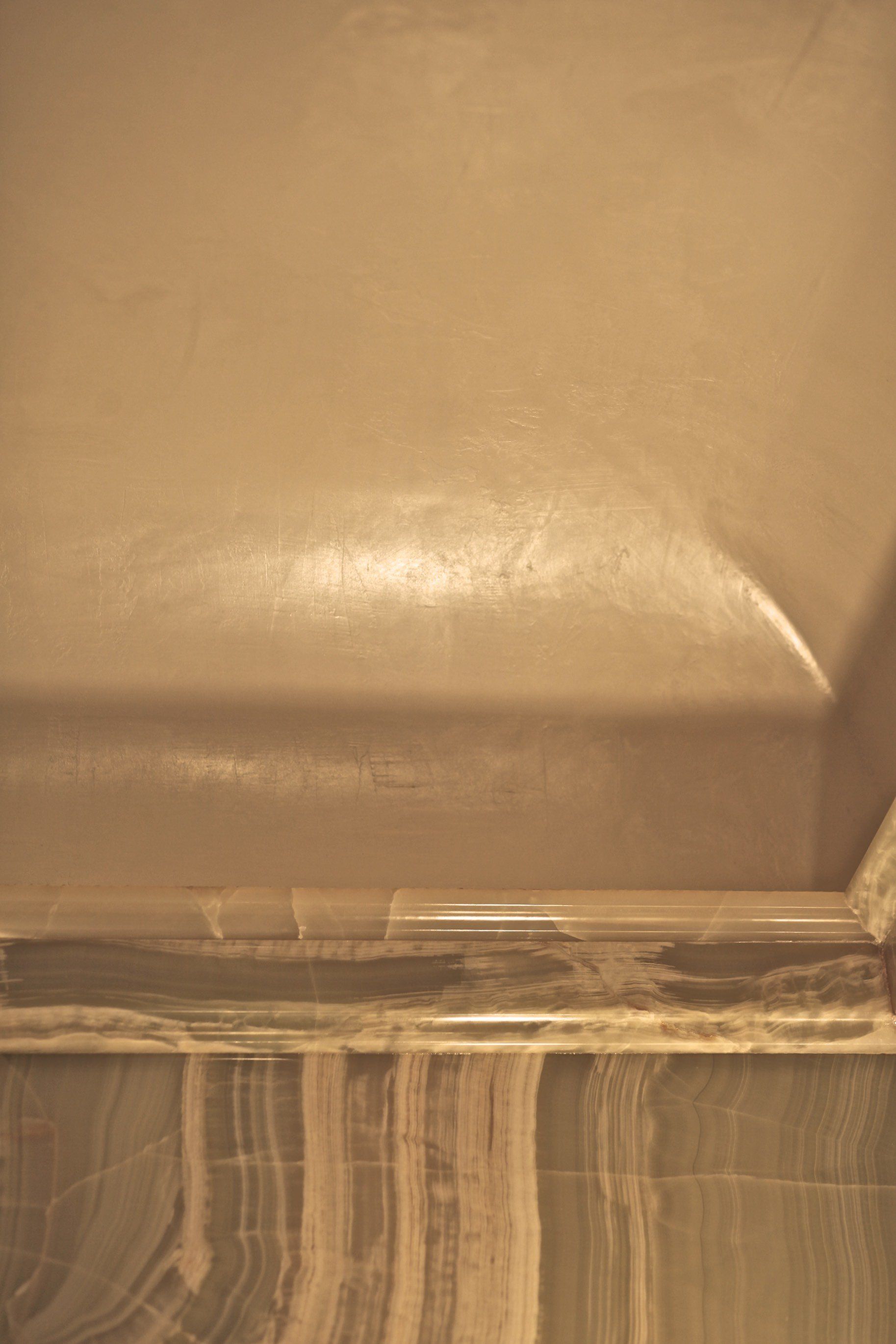 A close up of a bathtub with a marble counter top.
