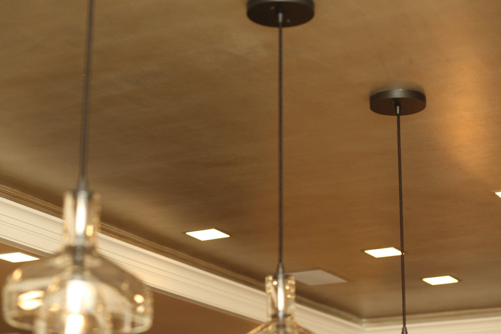 Three pendant lights are hanging from the ceiling in a room