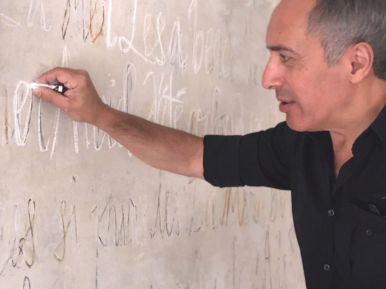 A man is writing on a white board with a marker