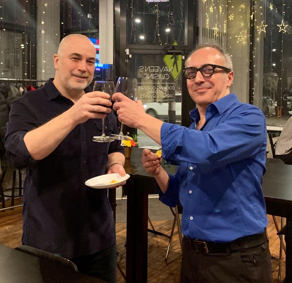 Two men are toasting with wine glasses in a restaurant