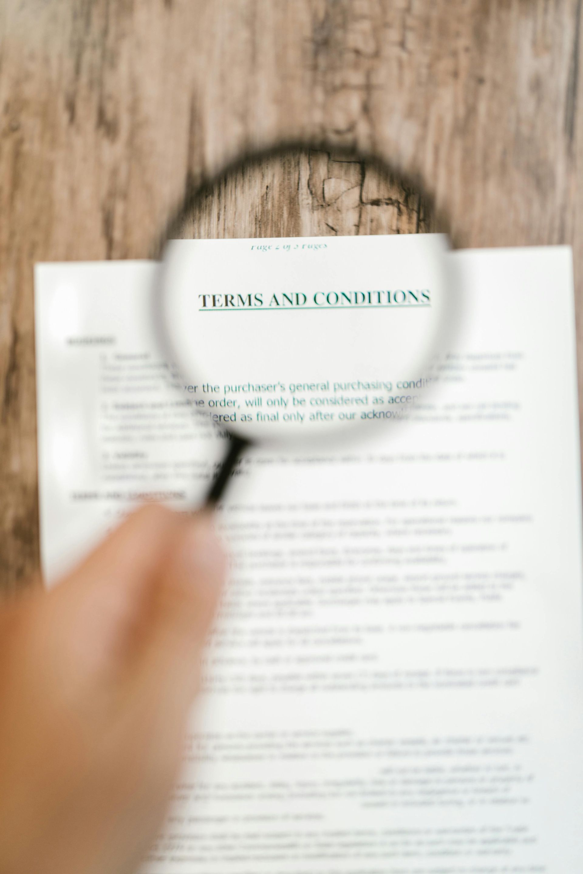 A person is holding a magnifying glass over a piece of paper.