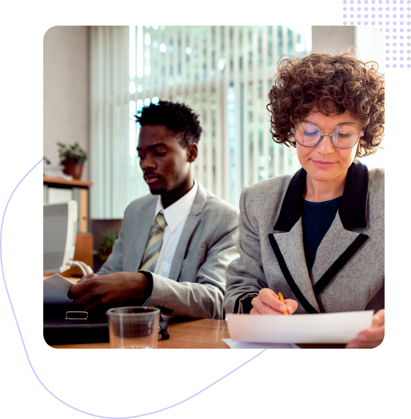 A man and a woman are sitting at a table looking at papers.