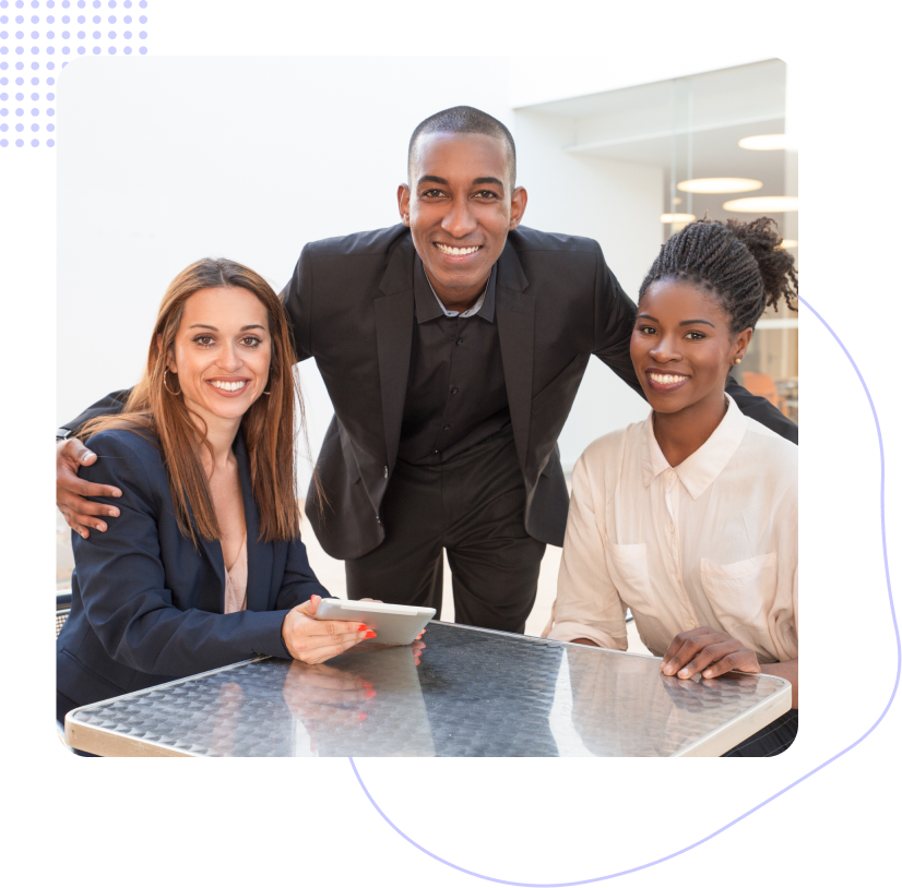 A man and two women are posing for a picture while sitting at a table