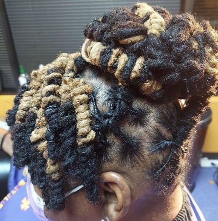 Woman with dark and blonde twisted hair styled in a bun.