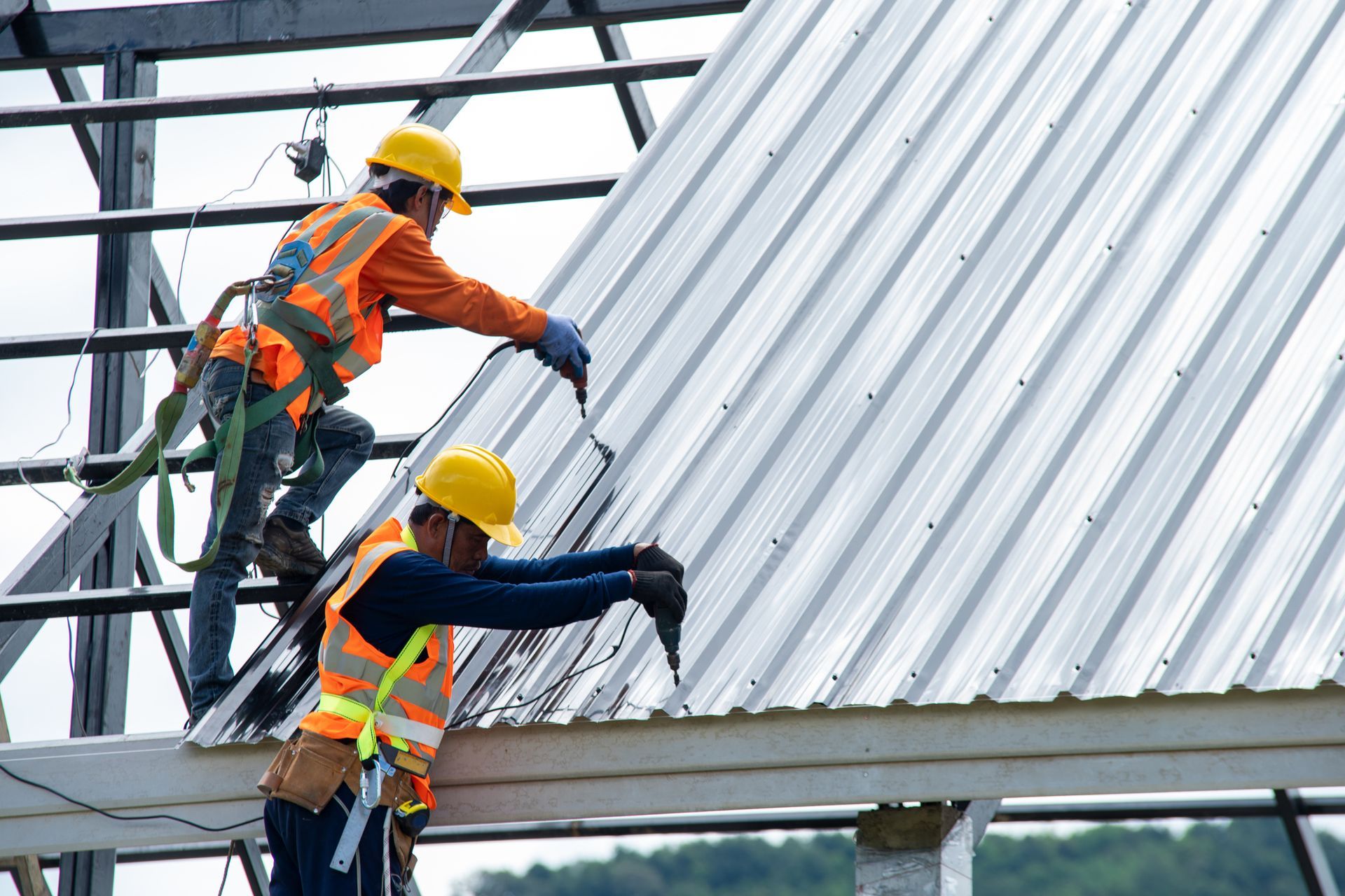 Roofing contractors installing a metal roof on a commercial building.