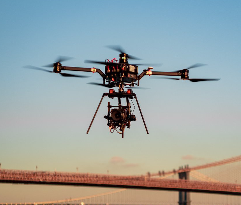 a drone with a camera attached to it is flying over a bridge