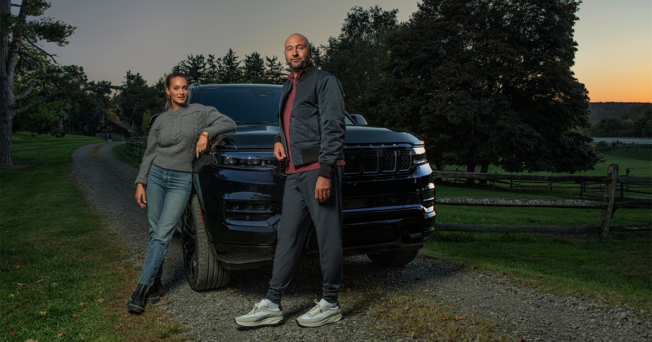 A man and a woman are standing next to a truck.