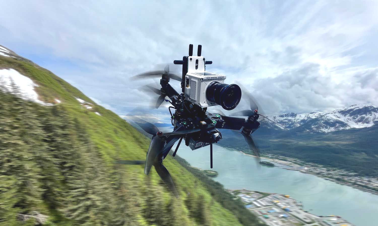 A drone is flying over a mountain with a river in the background.