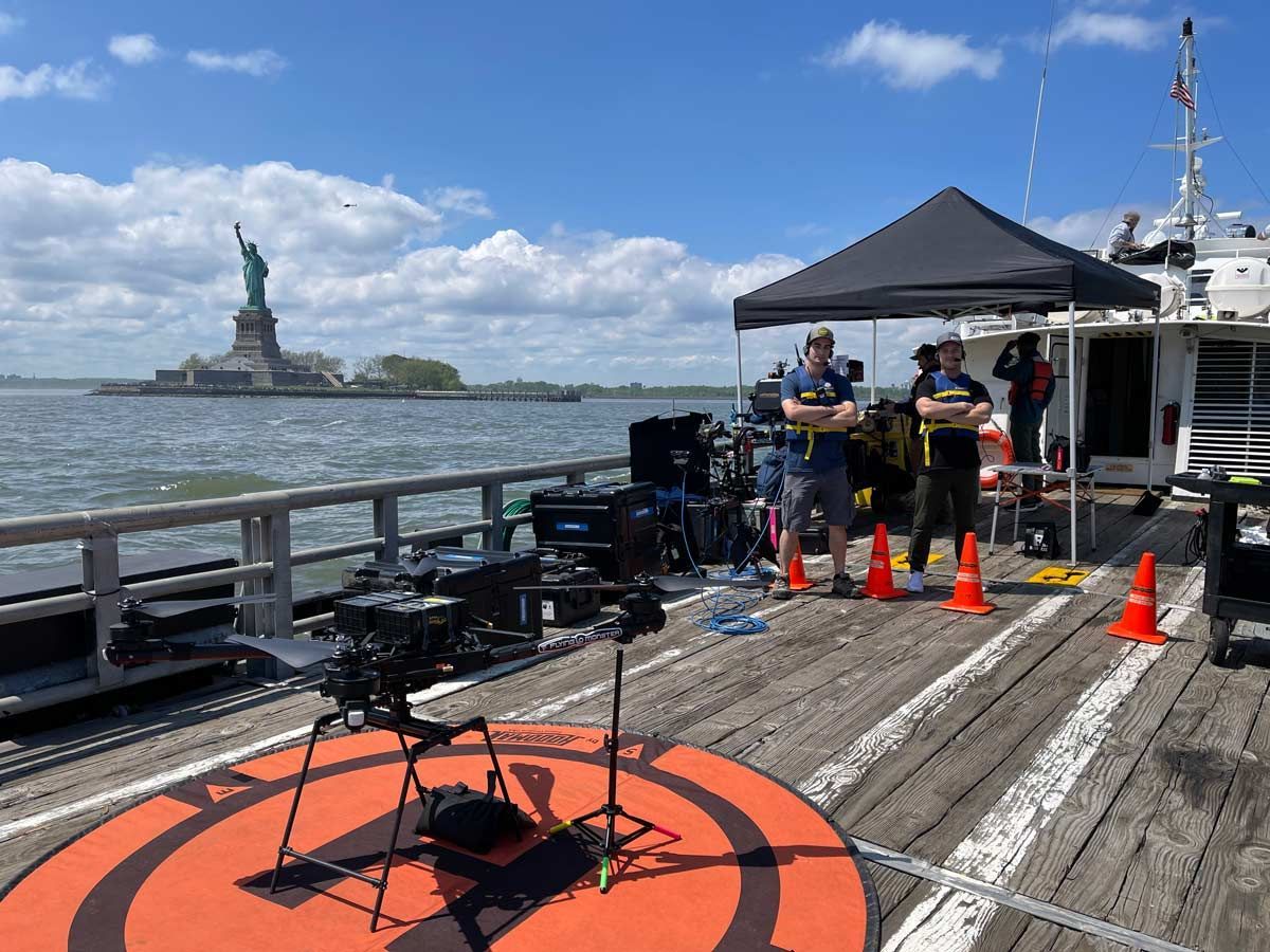 A statue of liberty is in the background of a dock