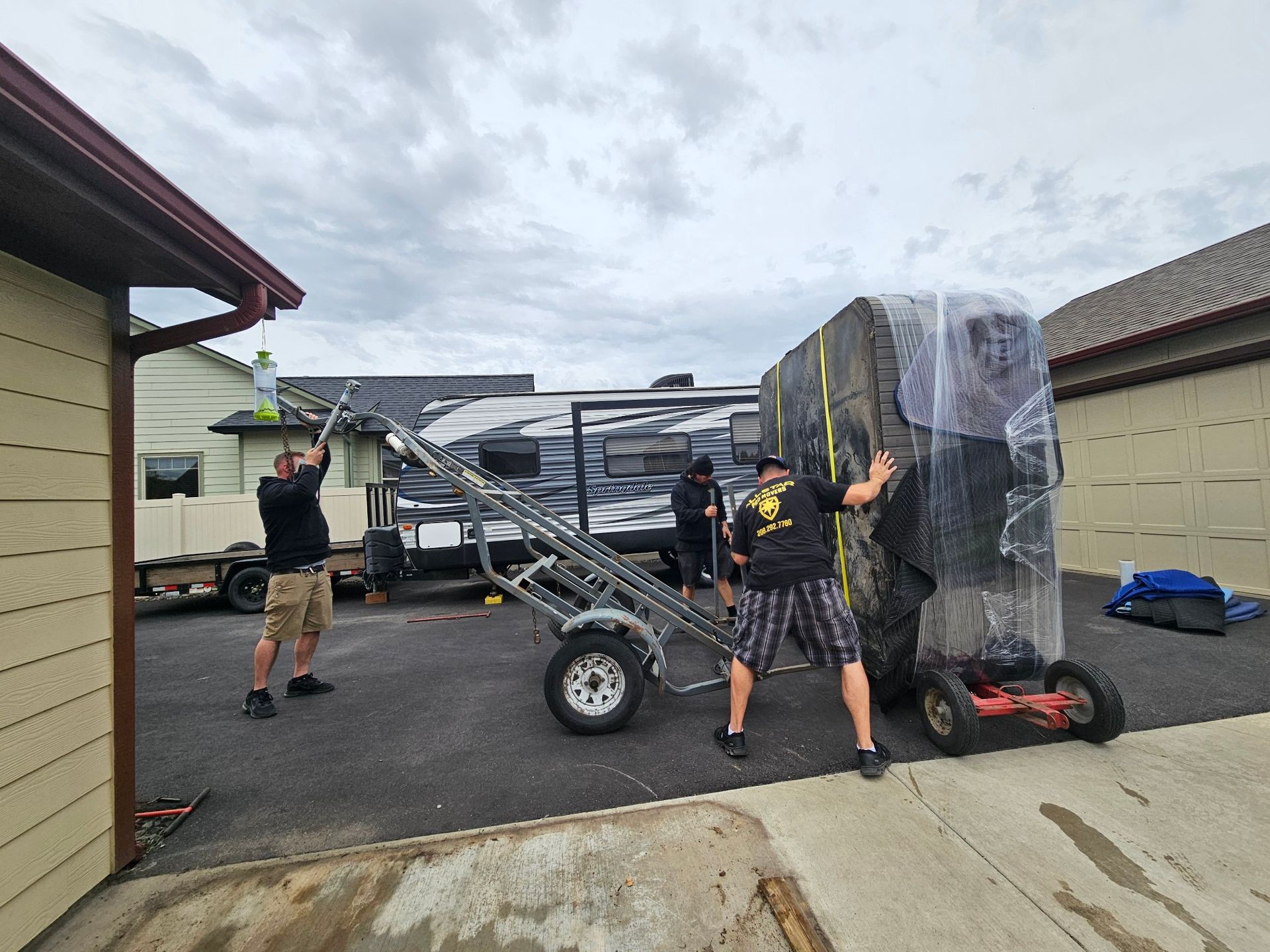 A group of men are loading a trailer into a garage.