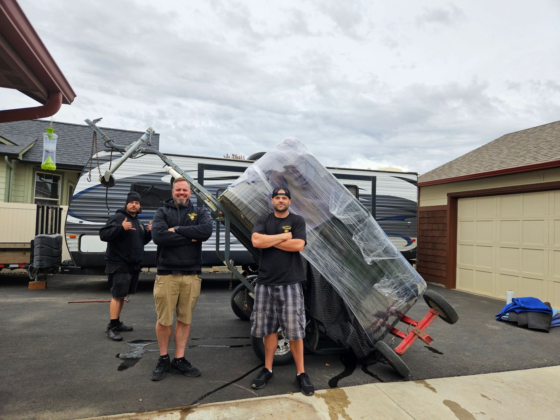 A group of men are standing in front of a trailer.