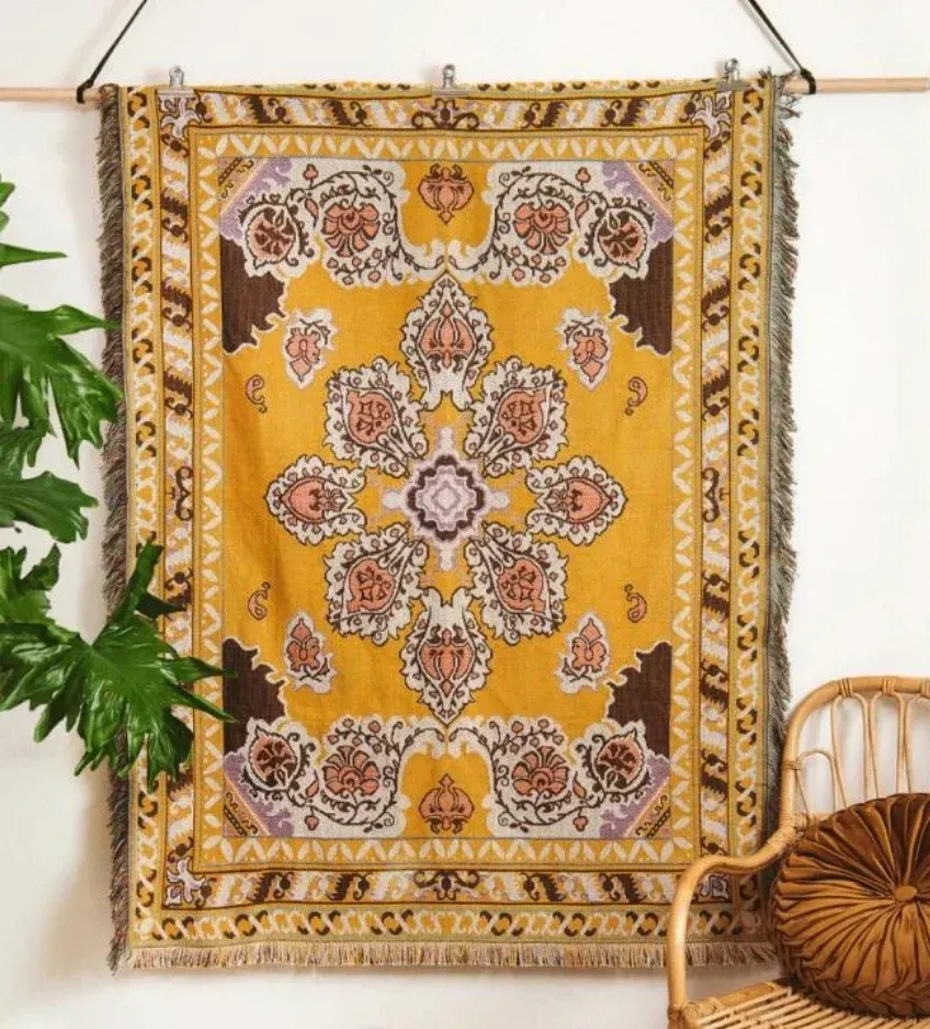 Yellow Tapestry With Floral Design, Hanging On A Wall Next To A Plant And A Wicker Chair — Bushfire Road Collective in Mareeba ,QLD
