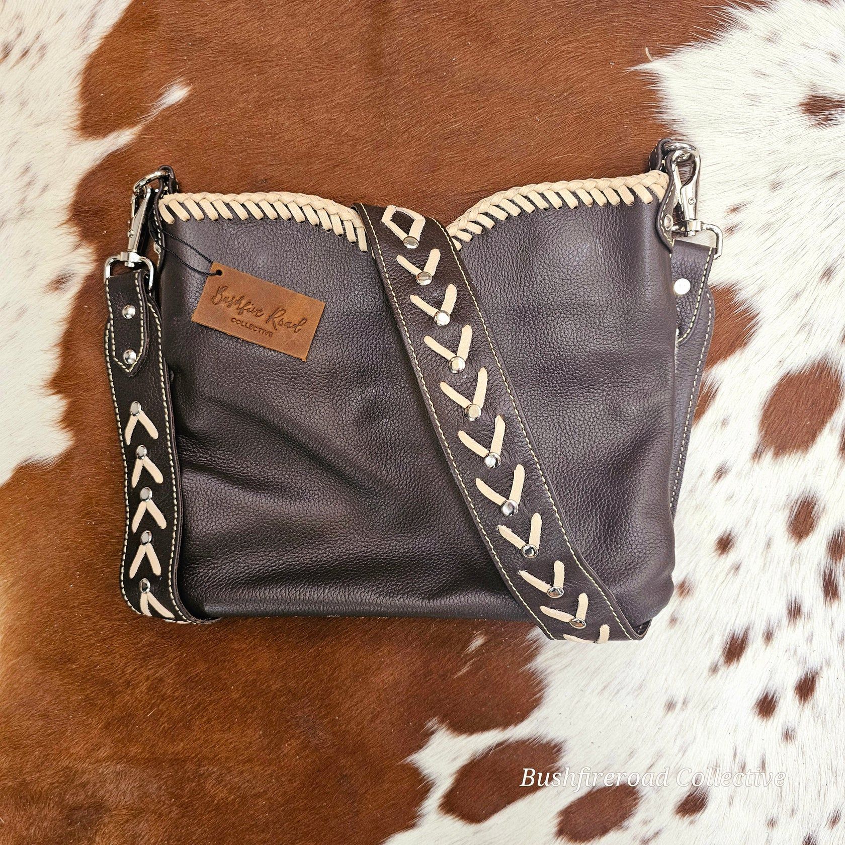 Dark Gray Leather Crossbody Bag With Light Stitching, On A Cowhide Rug — Bushfire Road Collective in Mareeba ,QLD