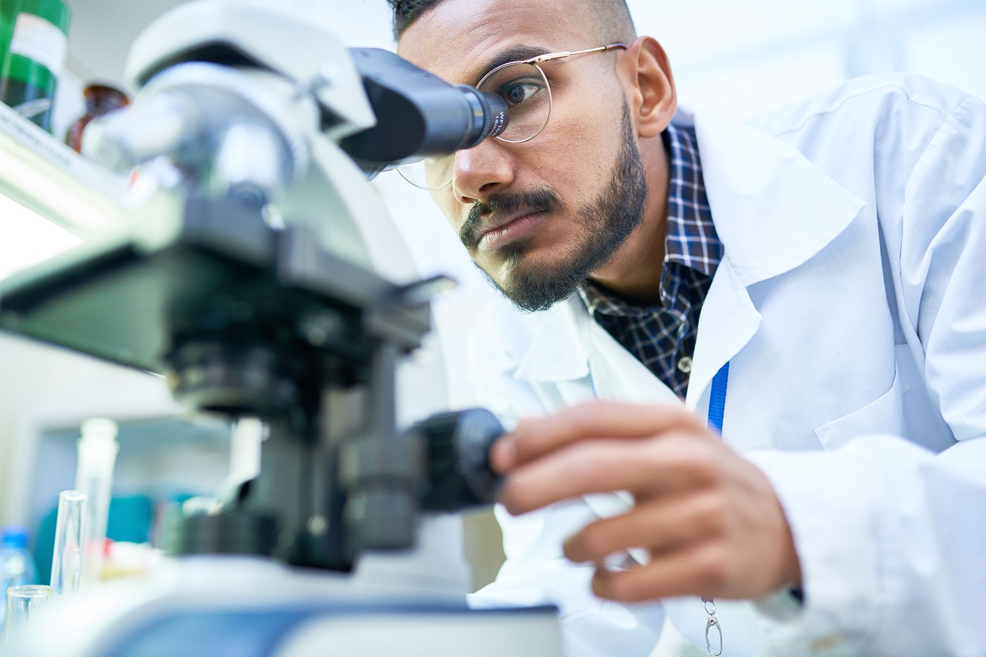Scientist examining a microscope in a bright laboratory