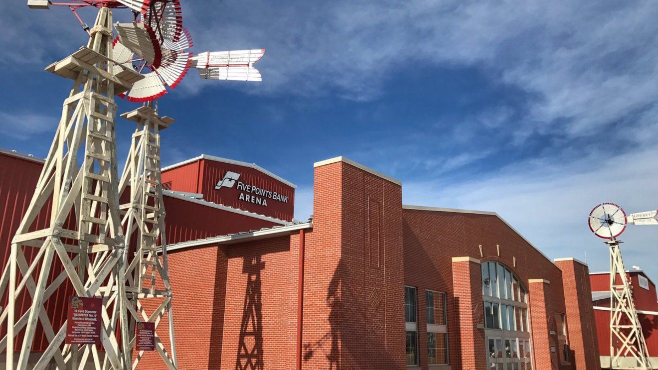 Red brick building with vintage amusement park rides against a blue sky