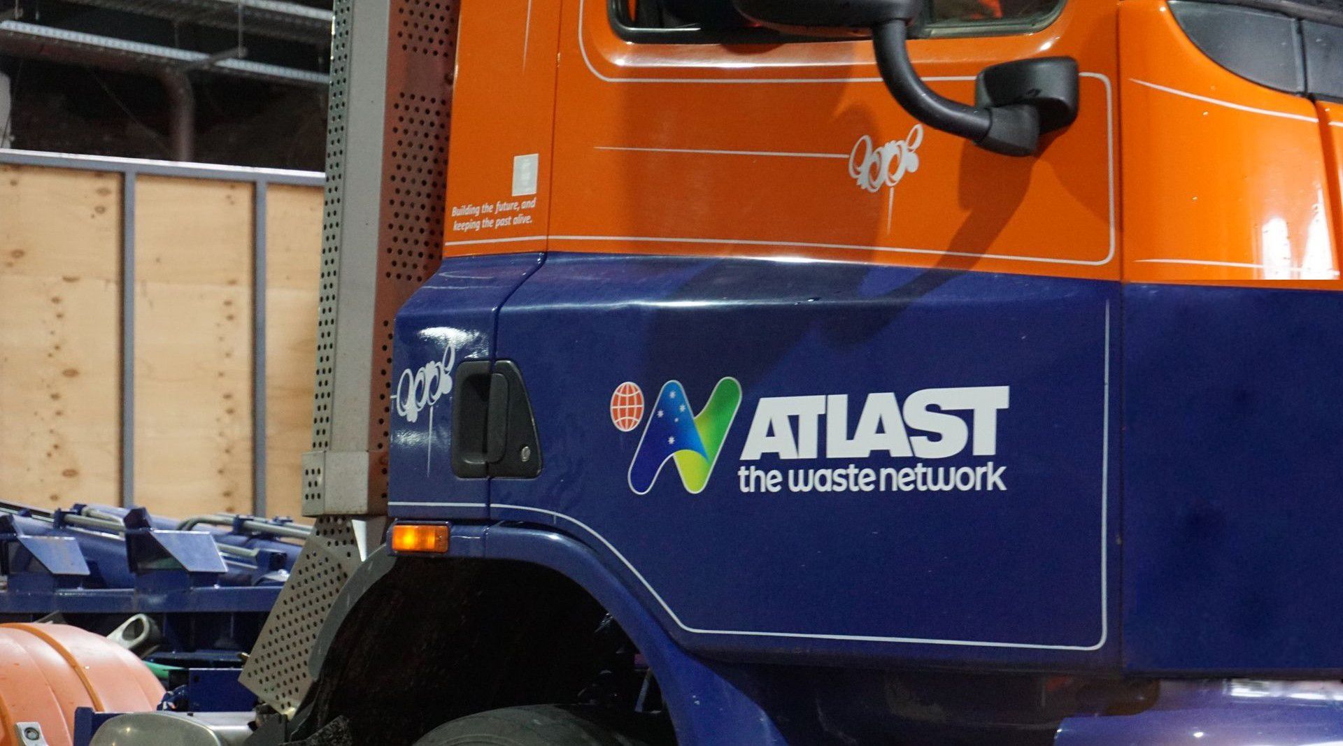 Orange and blue Atlas waste truck with logo 