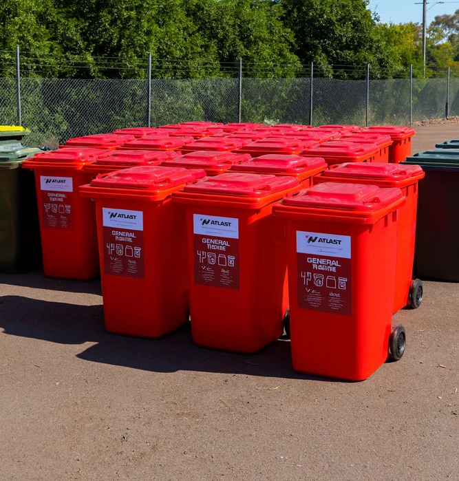 Red recycling bins arranged outside.