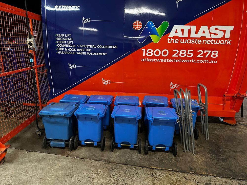 Blue recycling bins lined up near an orange and blue 