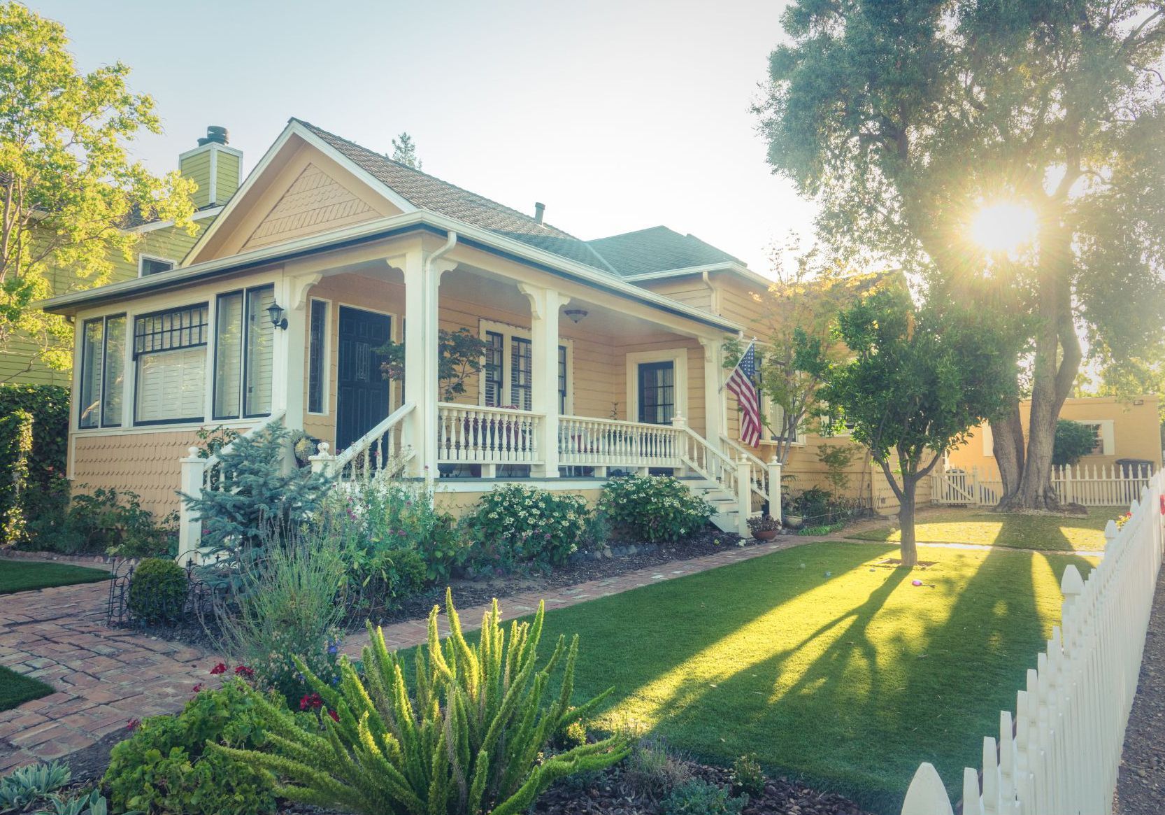 beautifully landscaped property with sun peaking through trees