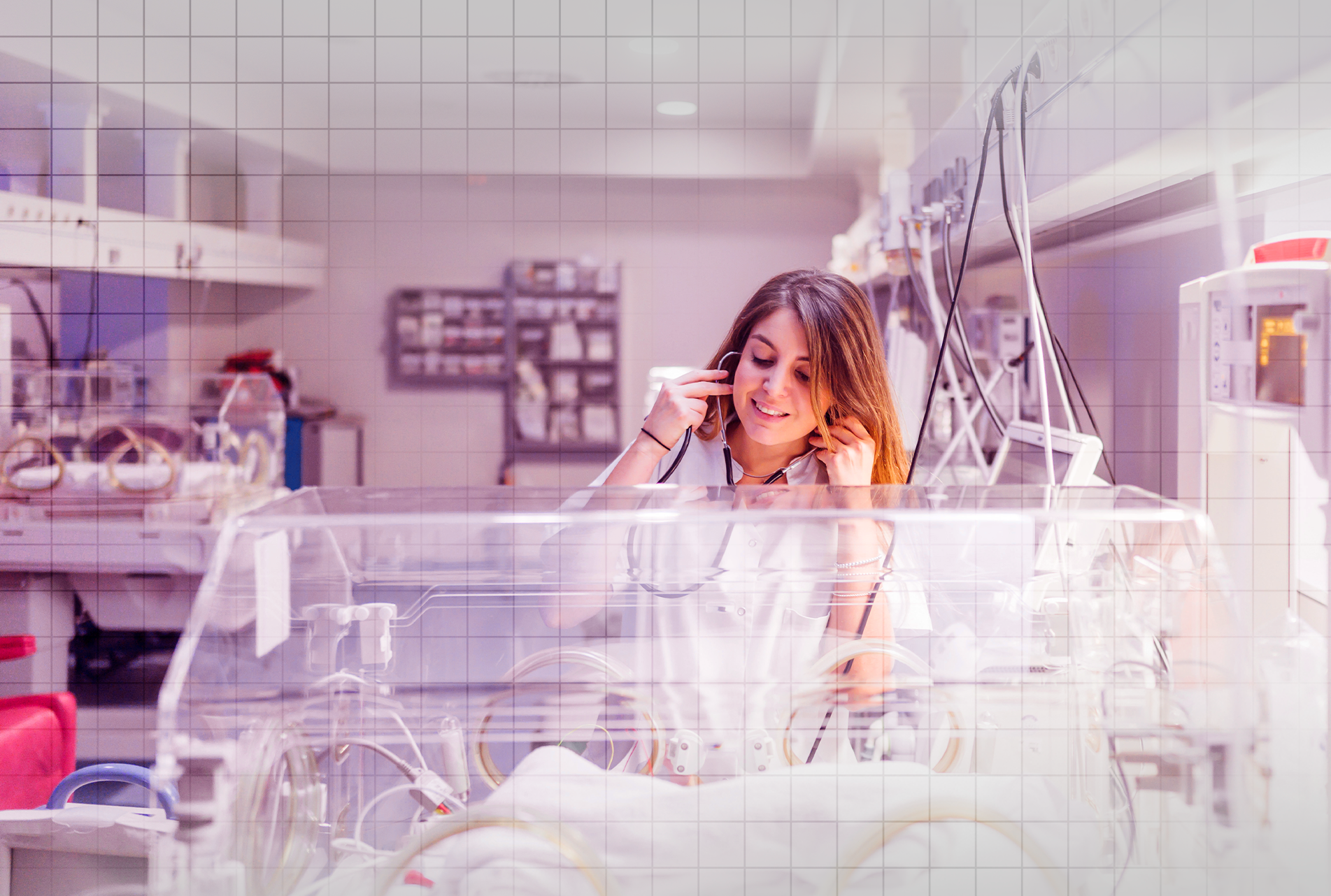 Uma enfermeira está falando ao celular enquanto olha para um bebê na incubadora.