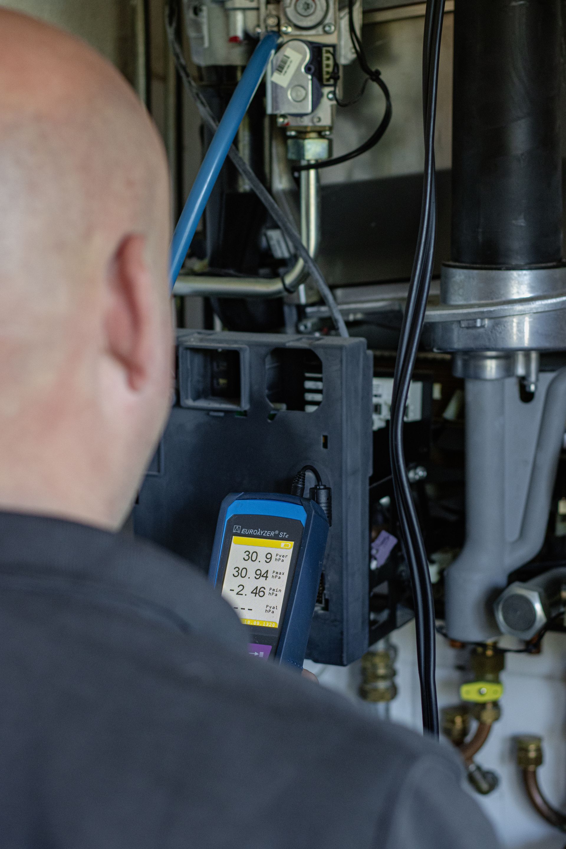 Iemand werkt met een schroevendraaier aan een elektriciteitskast.