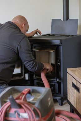 Een loodgieter houdt een sleutel in zijn hand en steekt zijn duim omhoog.