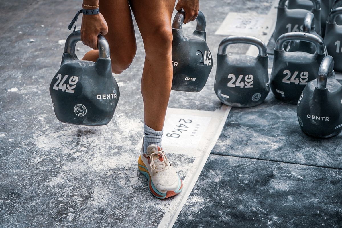 In een moderne sportschool met een blauwe baan en zwarte fitnessapparatuur.