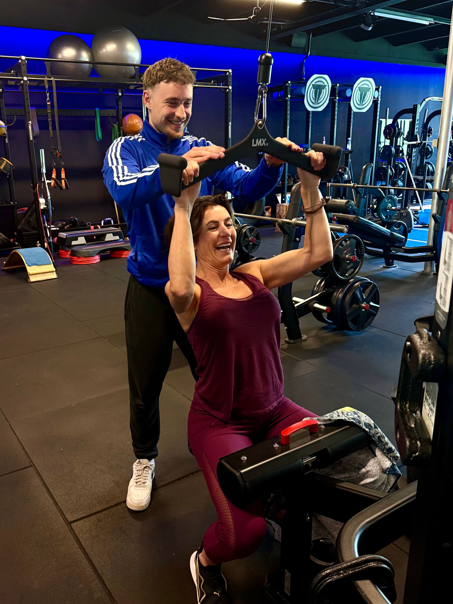 In een moderne sportschool met een blauwe baan en zwarte fitnessapparatuur.