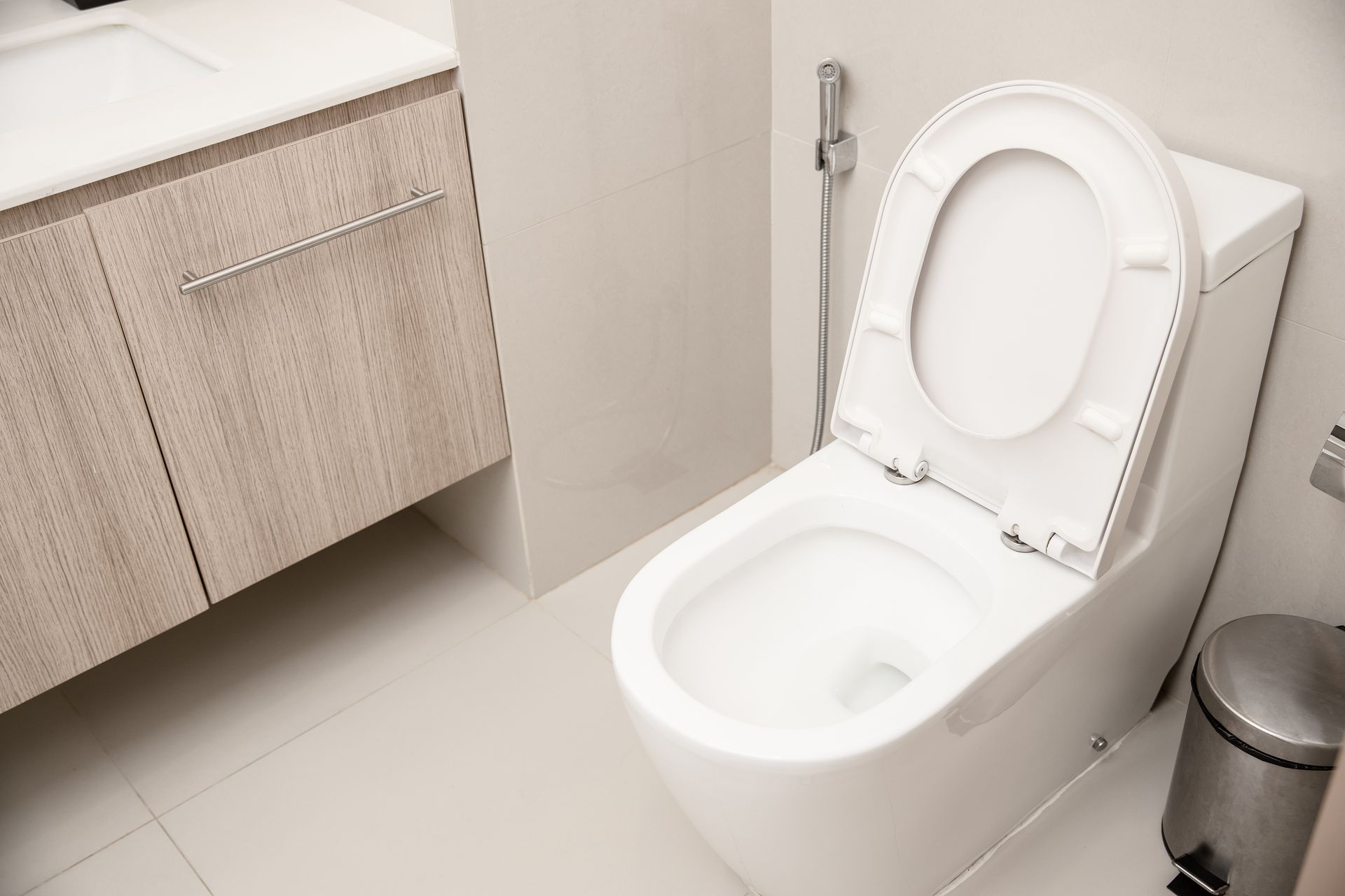 a white toilet is sitting in a bathroom next to a trash can .