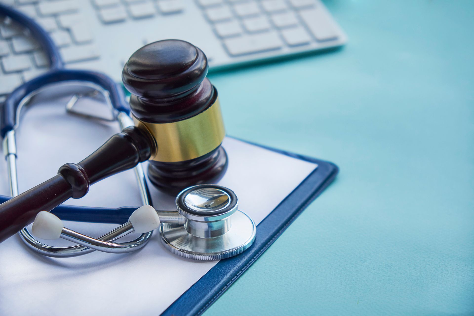 A judge 's gavel and stethoscope are sitting on top of a clipboard.