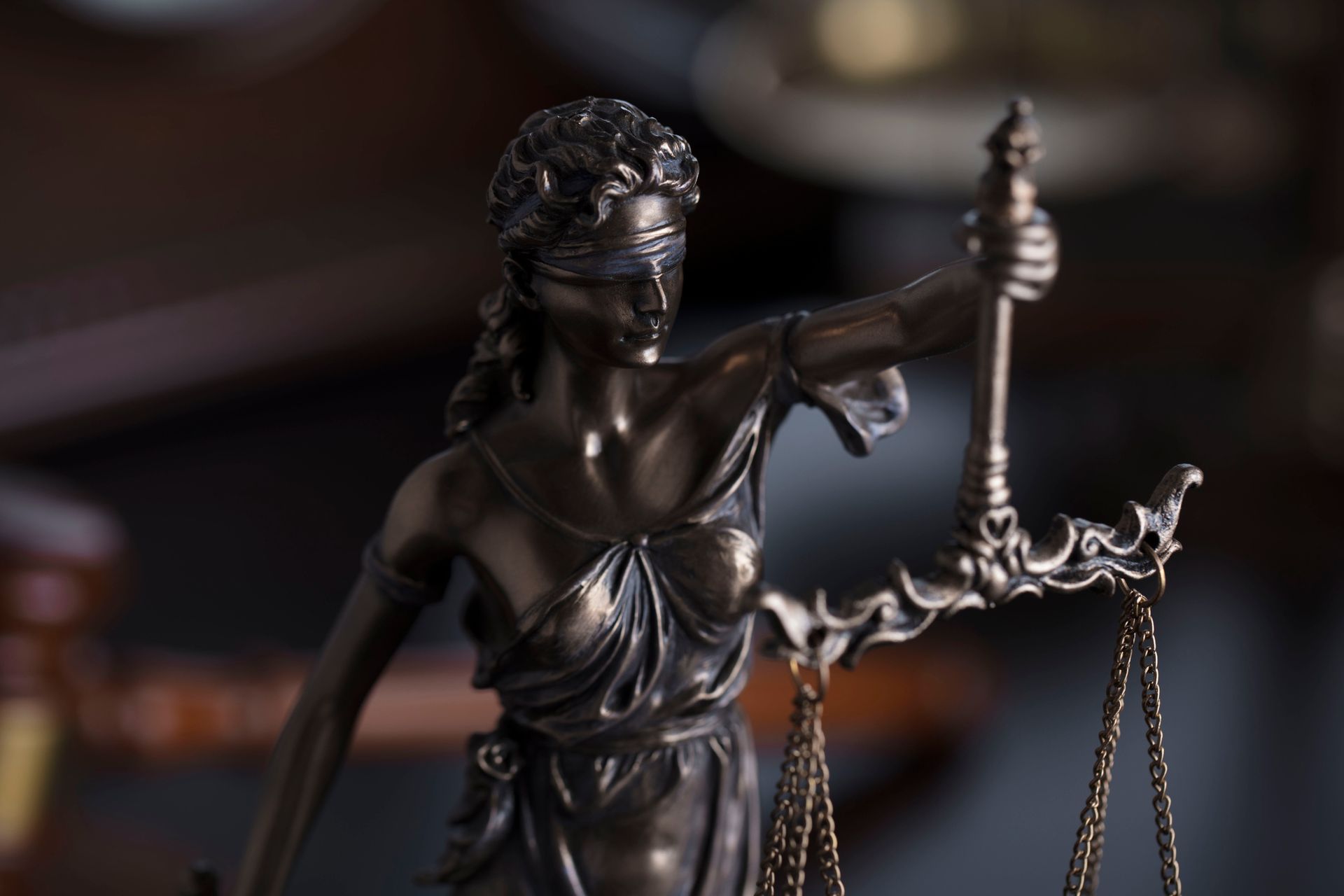 A statue of a blindfolded lady justice holding scales of justice.