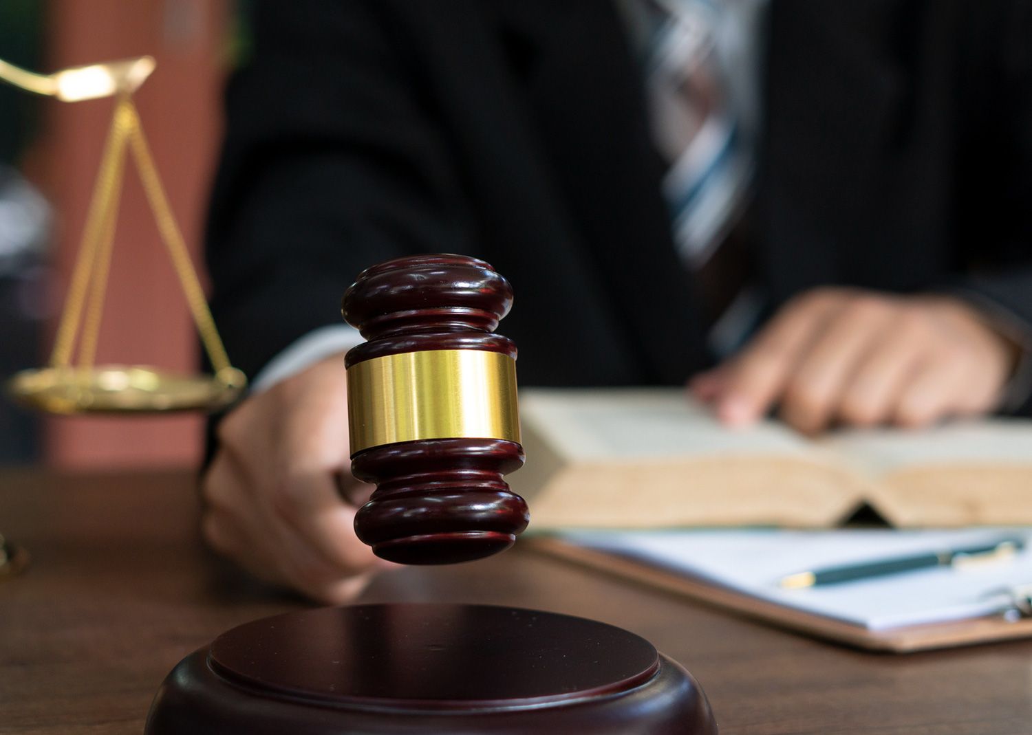 An Attorney is Holding a Wooden Gavel An Attorney is Holding a Wooden Gavel