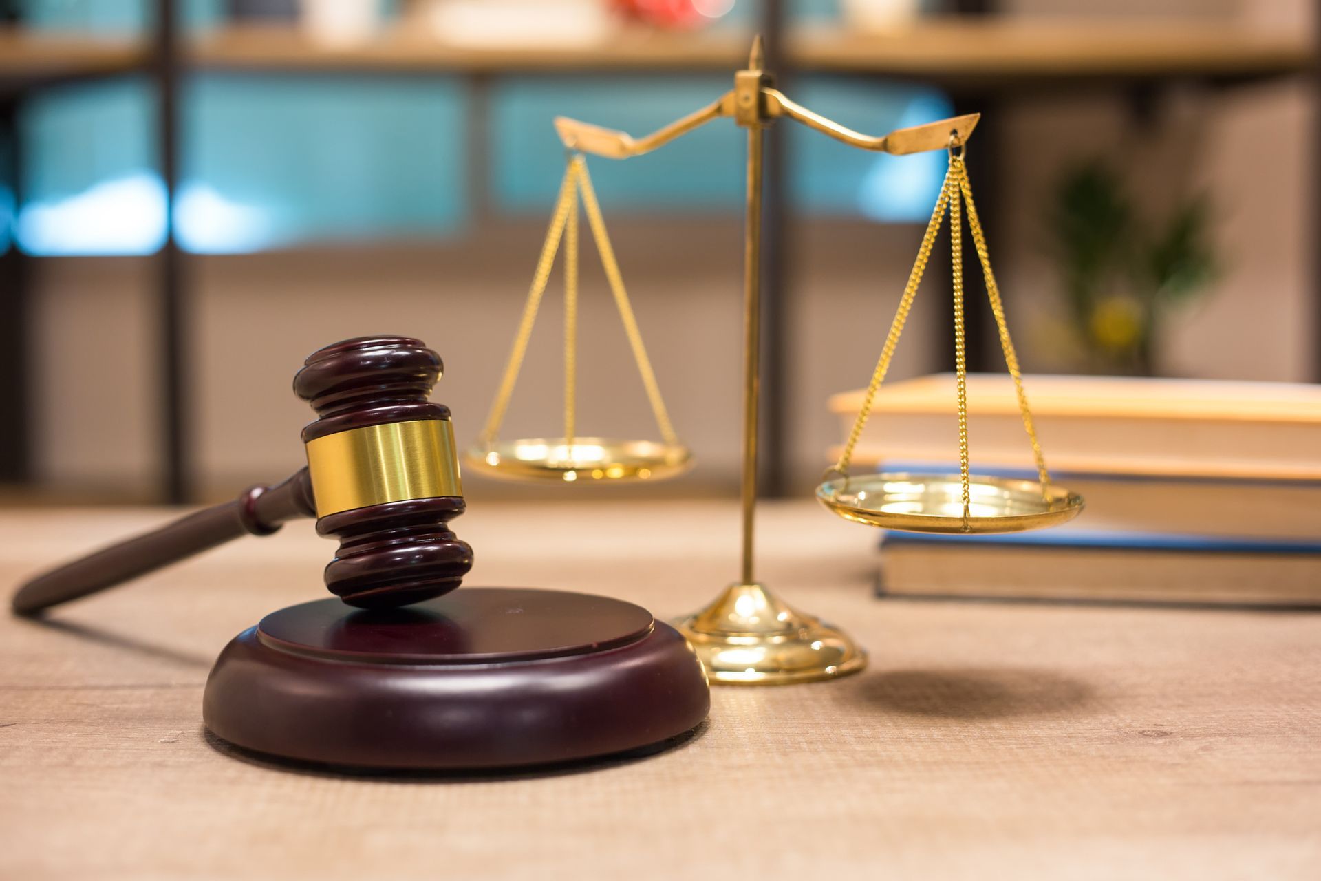 A judge's gavel and scales of justice are on a wooden table. A judge's gavel and scales of justice are on a wooden table.