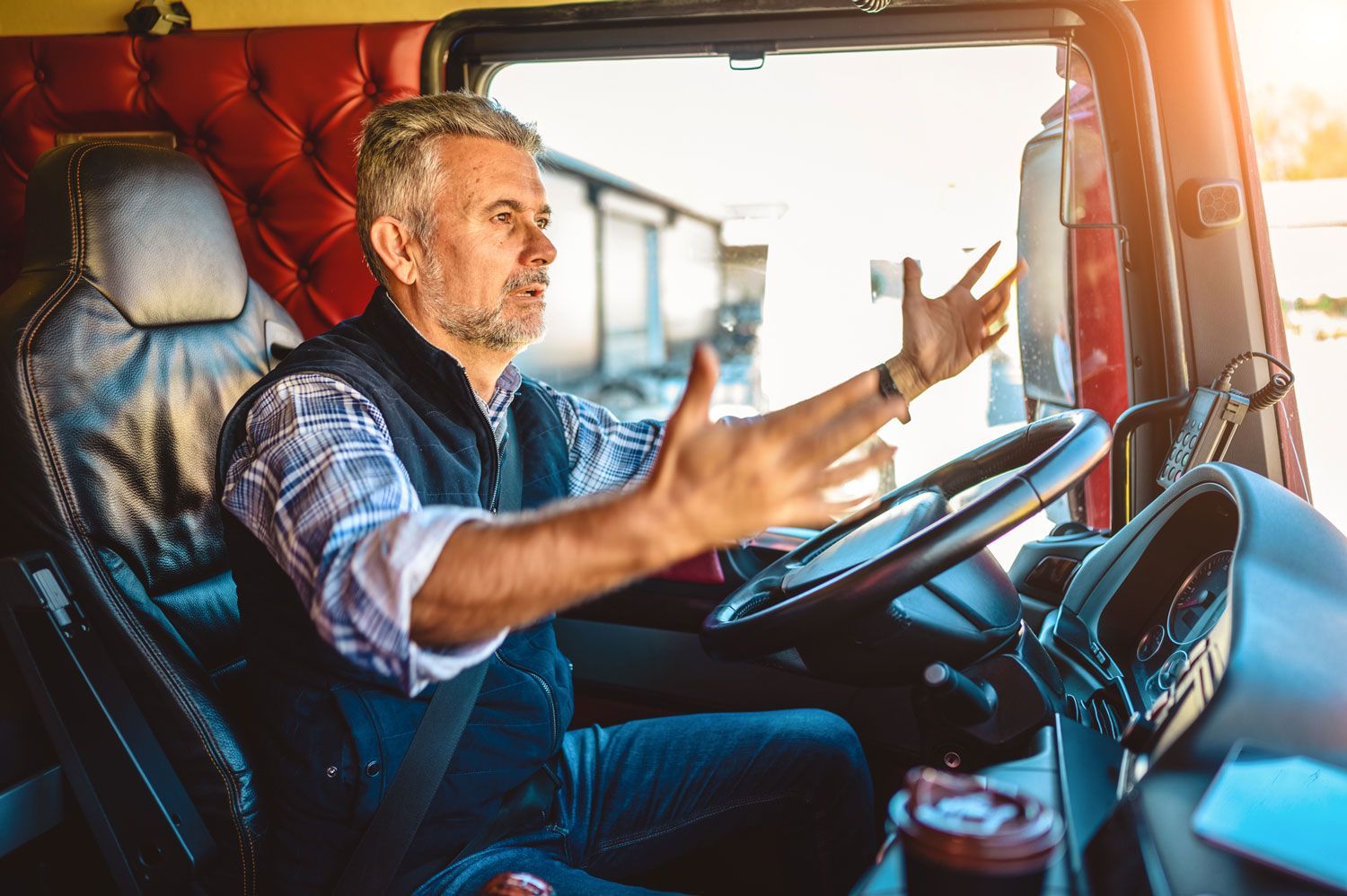 A man is sitting in the driver 's seat of a semi truck. A man is sitting in the driver 's seat of a semi truck.