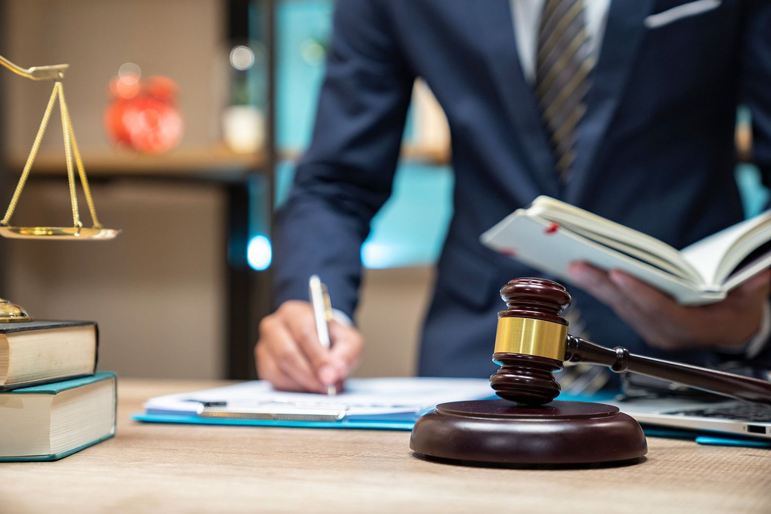 Gavel on Table and Attorney Writing on a Document Gavel on Table and Attorney Writing on a Document