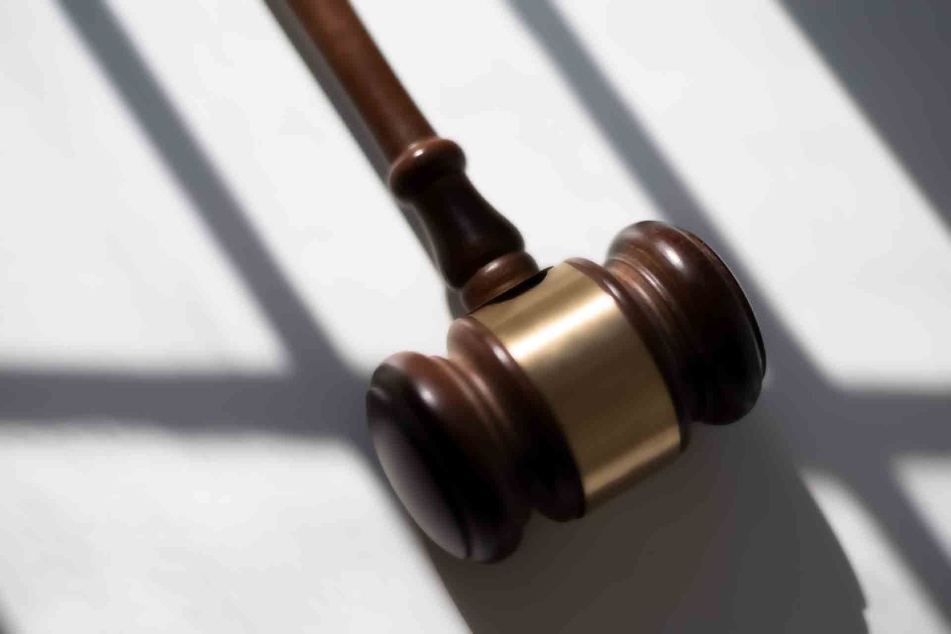 A wooden judge 's gavel is sitting on a white surface.