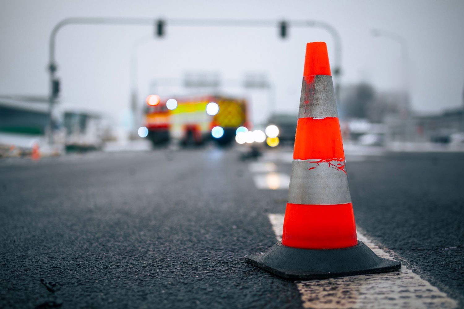 A traffic cone is sitting on the side of a road.