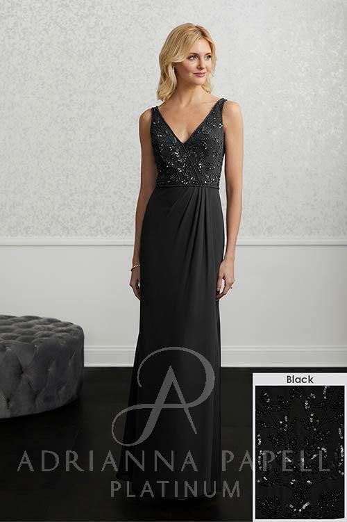 Woman in a black sequin bodice gown, standing in a room, by Adrianna Papell.