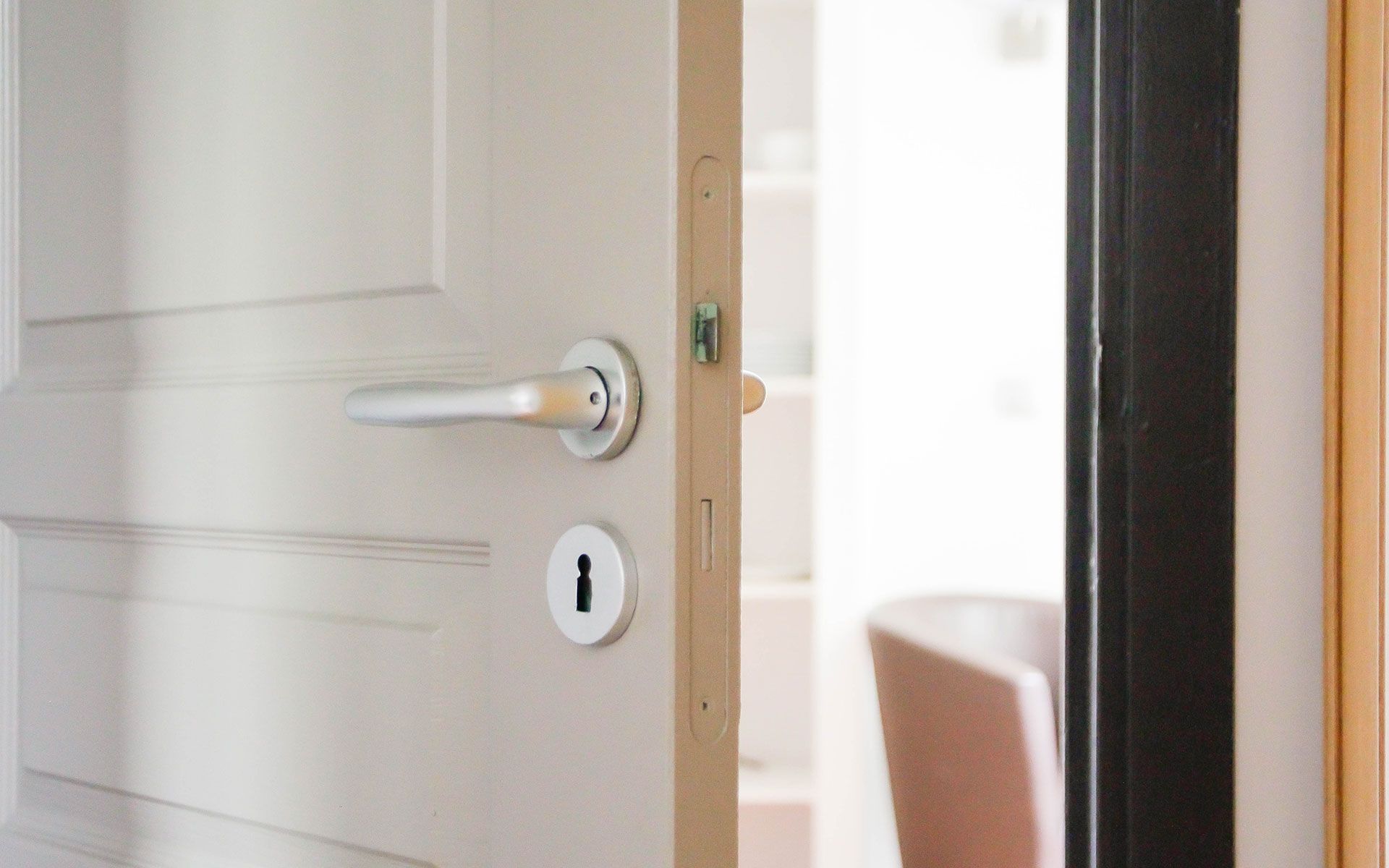 A close up of an open door with a keyhole in it.
