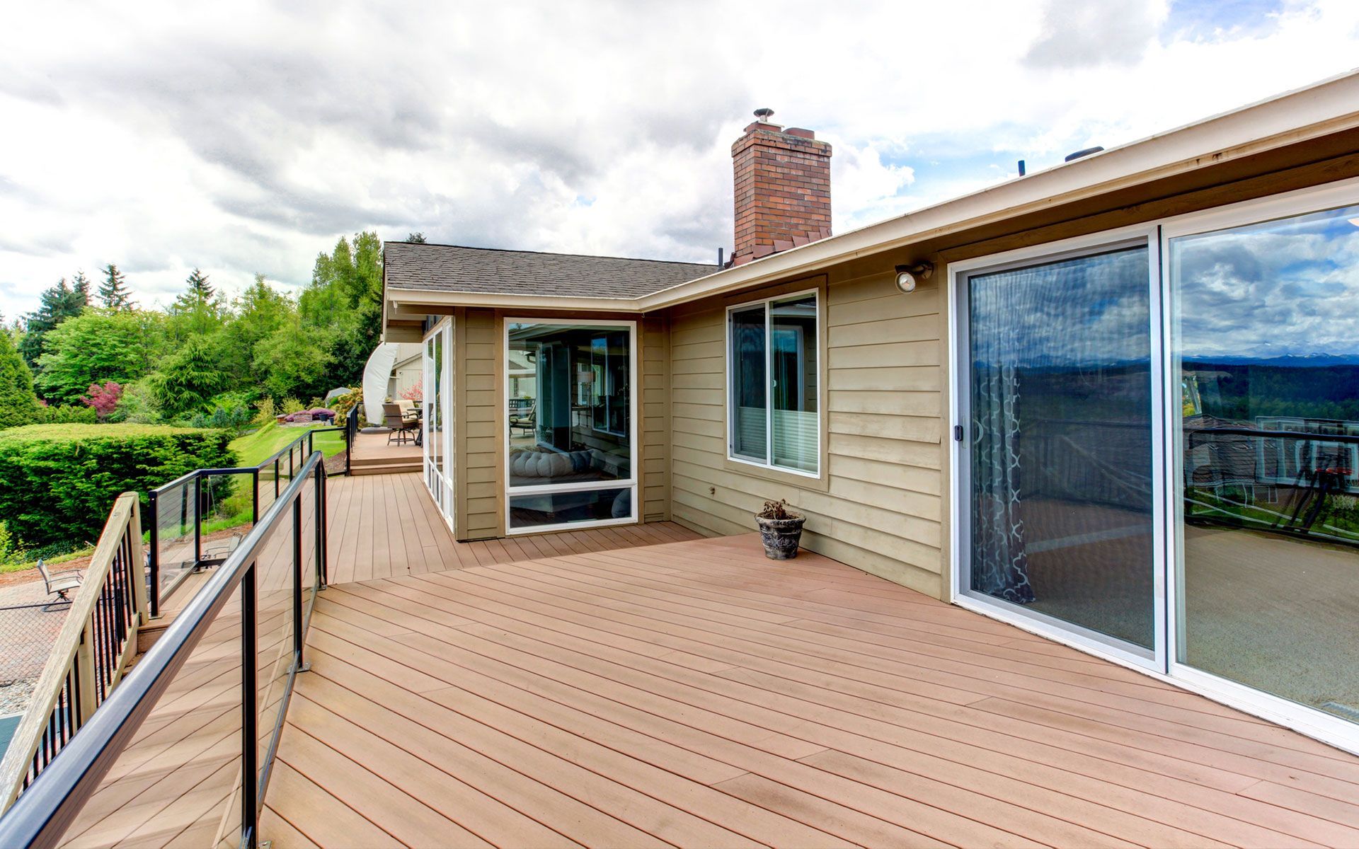 There is a large deck with sliding glass doors leading to the back of the house.