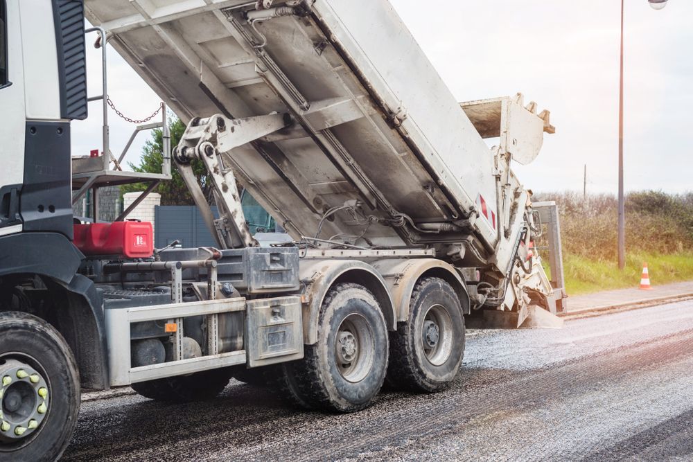 Dump Truck Unloading Asphalt on a Road Construction Site — Barkly Hire in Richmond, QLD