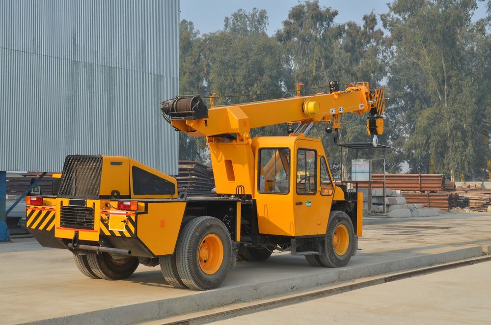 Yellow Mobile Crane Parked Outdoors Beside a Large Building — Barkly Hire in Richmond, QLD