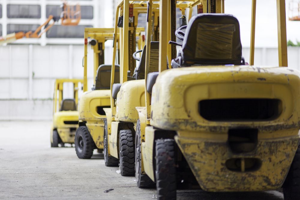 Yellow forklifts lined up in an industrial warehouse aisle — Barkly Hire in Karumba, QLD