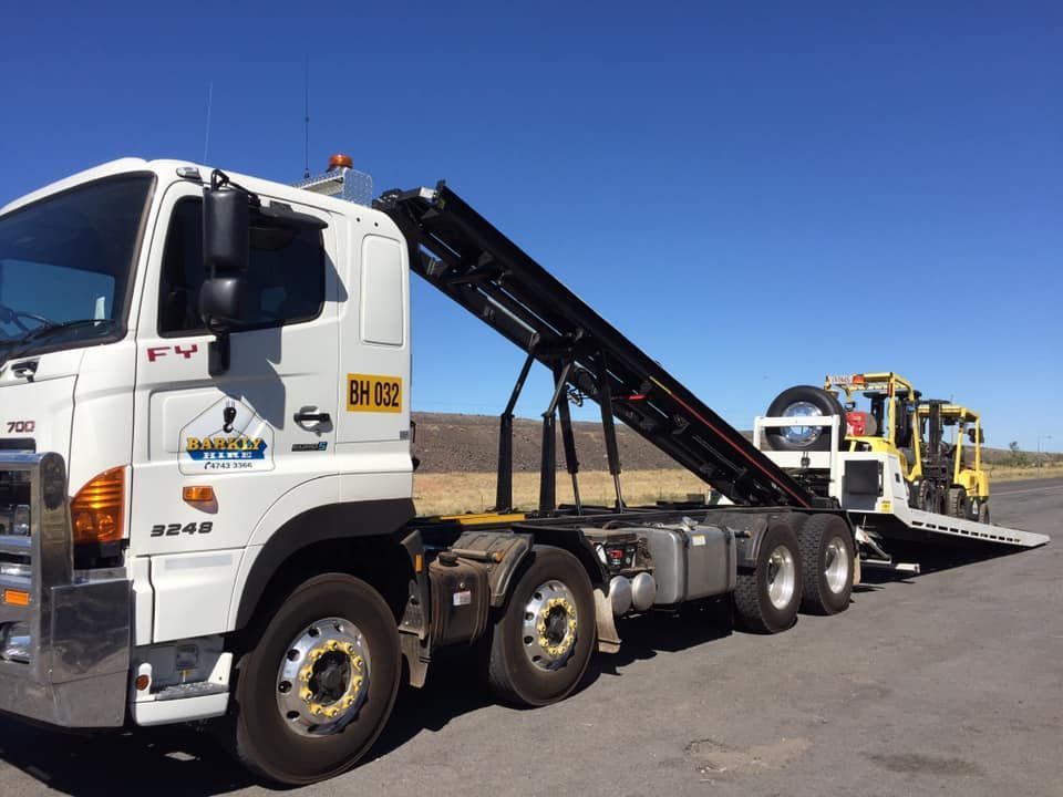 White Truck With a Yellow Forklift Attached to It is Parked on the Side of the Road — Barkly Hire in Ryan, QLD